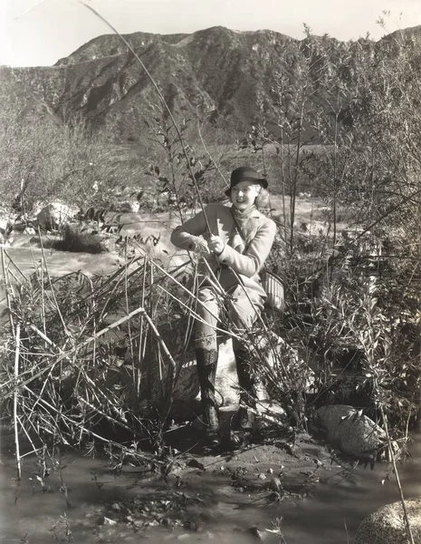 Donna pesca sulla riva del fiume — Foto Stock