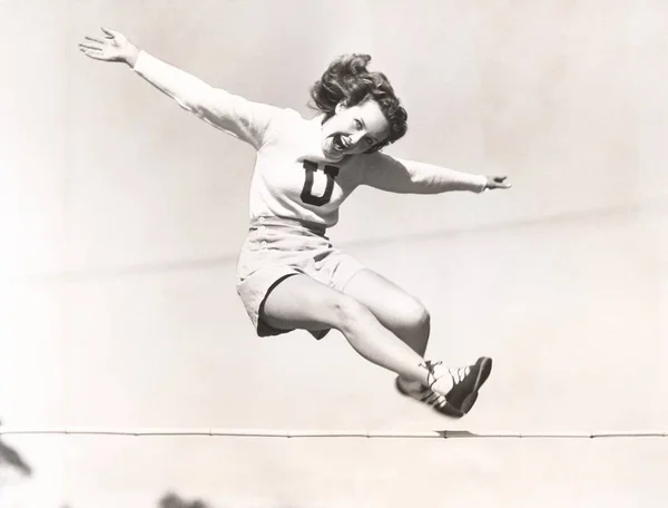Frau springt über Hürde — Stockfoto