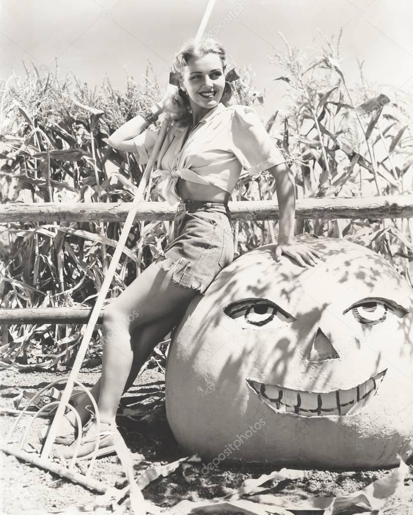 woman sitting on pumpkin