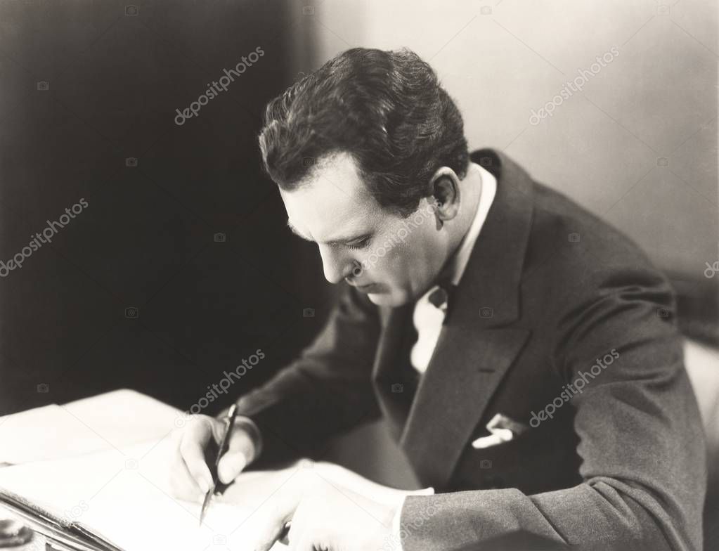 Businessman writing in book