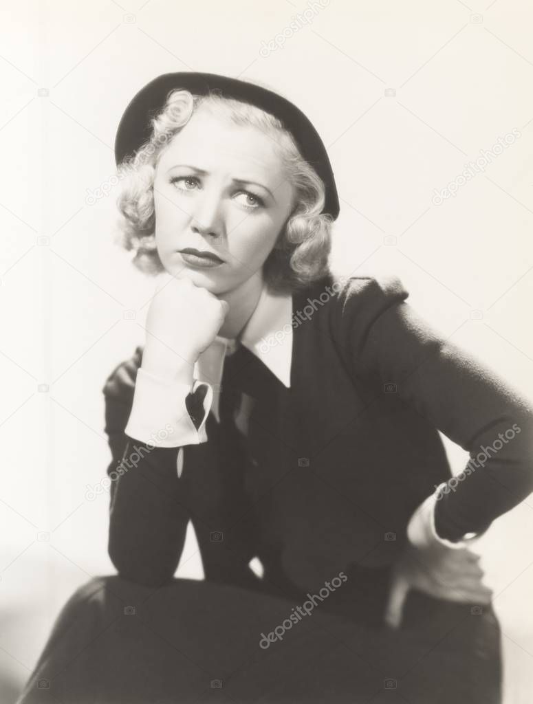 woman sitting with hand on chin