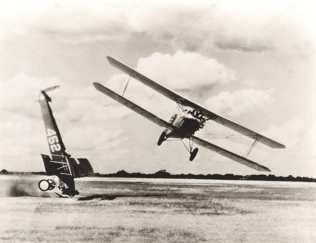 Biplane flying by crashed air vehicle
