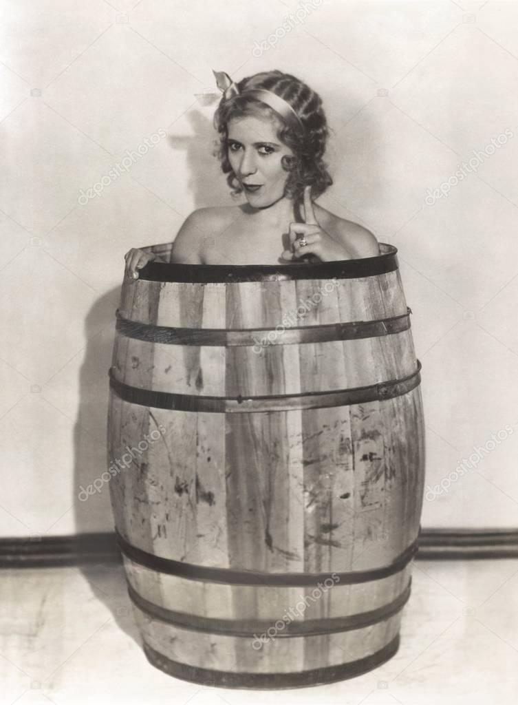 woman sitting in wooden barrel