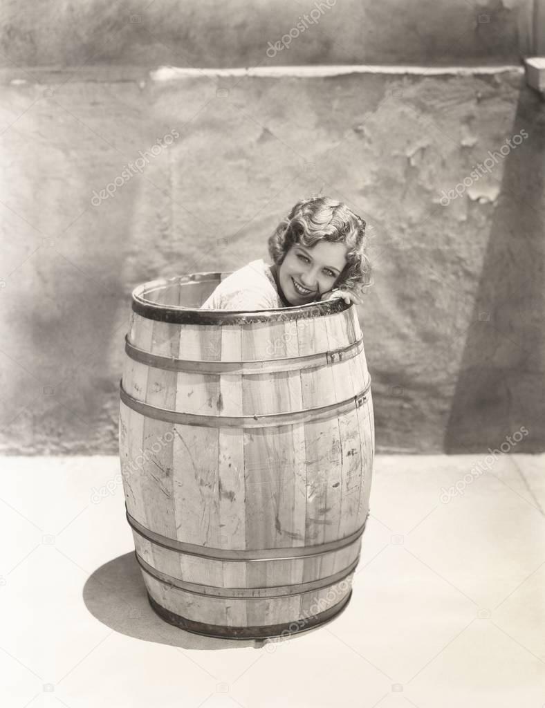 woman sitting inside barrel 