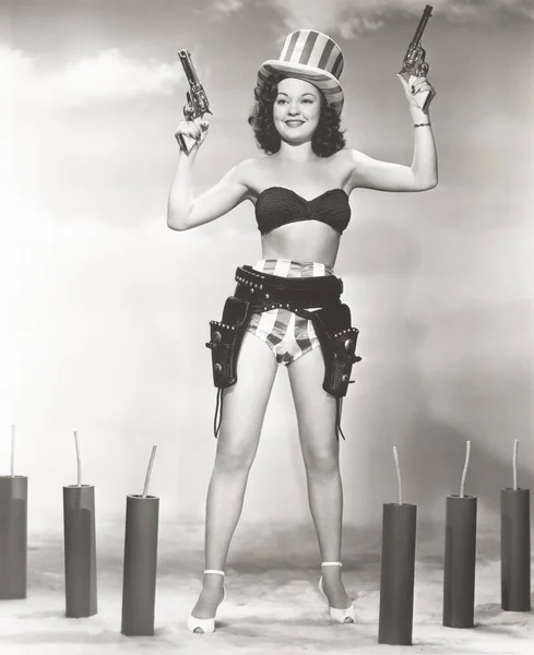 Mulher de biquíni segurando armas — Fotografia de Stock