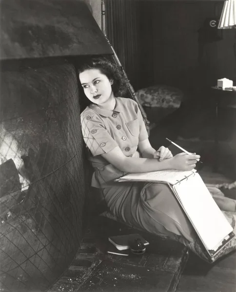 Mujer sentada junto a la chimenea —  Fotos de Stock