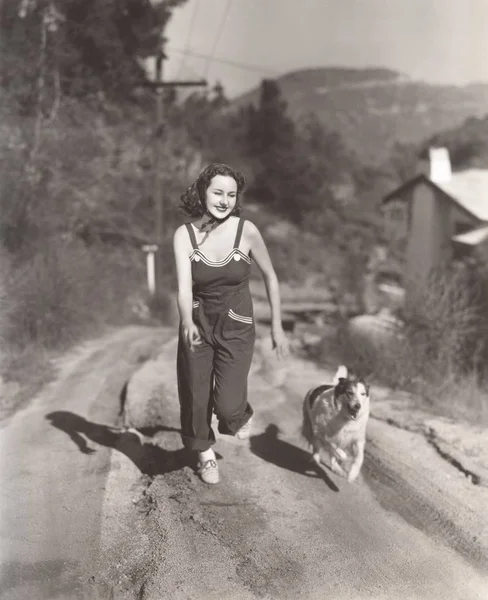 女人和狗在大街上运行 — 图库照片