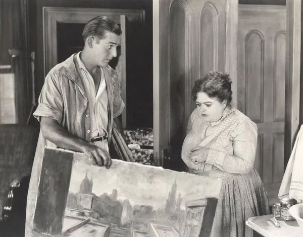 Nő keresi a festészet az ember által tartott — Stock Fotó
