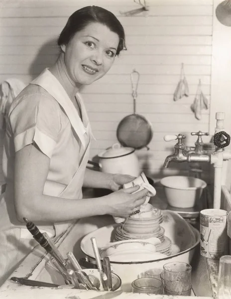 Femme de ménage essuyant tasse dans la cuisine — Photo