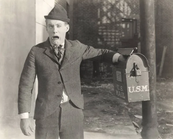 Homme insérant la main dans la boîte aux lettres — Photo