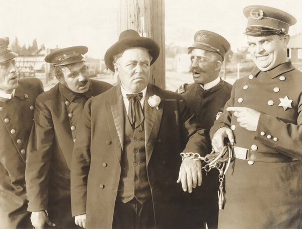 Полицейский арестовывает преступника
