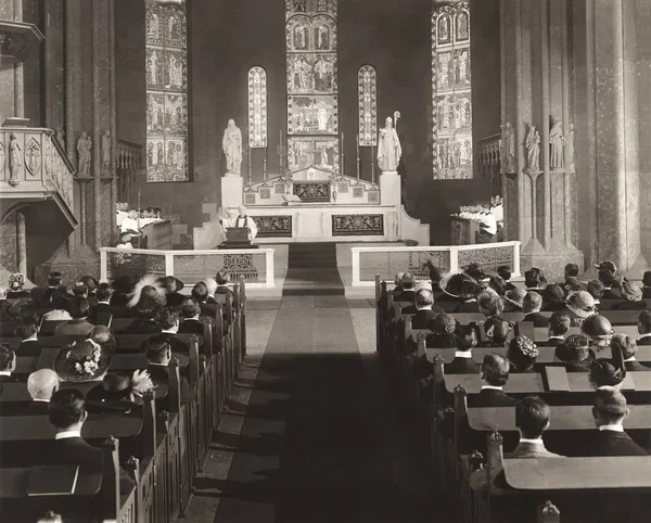 Männer und Frauen sitzen auf Kirchenbänken — Stockfoto