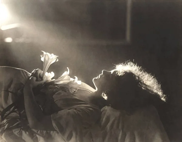 Mulher com flores dormindo na cama — Fotografia de Stock