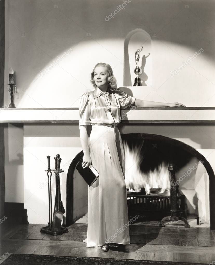 woman standing by fireplace