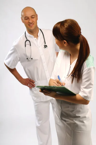 Enfermera Médica Escribiendo Notas Médico Leyéndolo Sobre Hombro —  Fotos de Stock