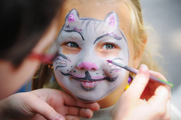 Face painting - white cat painted on small girl face