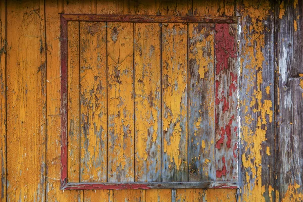 오래 된 나무집 벽에 있는 노랑, 빨강, 주황 페인트 — 스톡 사진
