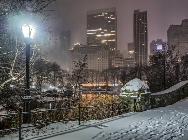 Gapstow Bridge is one of the icons of Central Park, Manhattan in New York City during snow storm at night