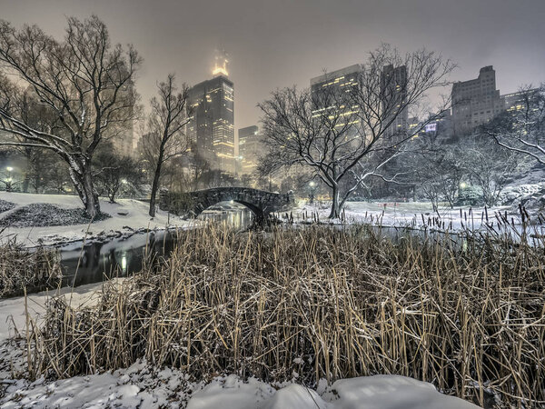 Gapstow Bridge is one of the icons of Central Park, Manhattan in New York City during snow storm at night