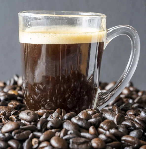 Espresso auf einem Haufen Bohnen — Stockfoto