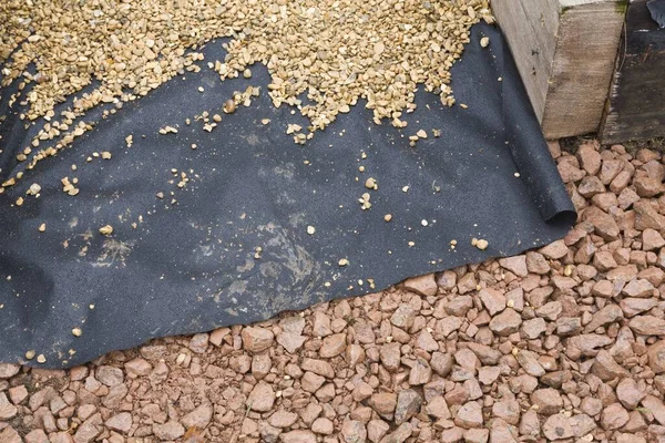 Hard landscaping materials - aggregate, weed membrane and gravel used to lay a garden path, UK