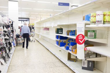BUCKINGHAM, İngiltere - 16 Mart 2020. Tesco süpermarket müşterileri Coronavirus COVID-19 salgını nedeniyle boş raflara bakıyorlar.