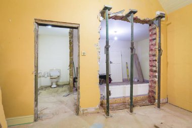 İngiltere 'deki bir evdeki iç tuğla duvarı kaldırdıktan sonra sahne donanımlarıyla desteklenen yeni duvar açılması