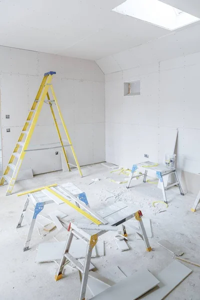 Plasterboard installation in a new build home interior with tools and step ladder