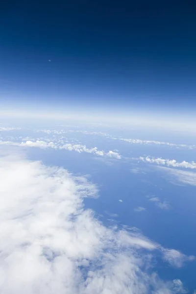 View from window of an airplane of the moon, blue sky, clouds and Atlantic ocean. Depicts Earth, environment, global concept