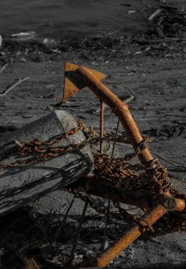 Yaşlı paslı çapa ve şamandıra kıyıda yatıyor.