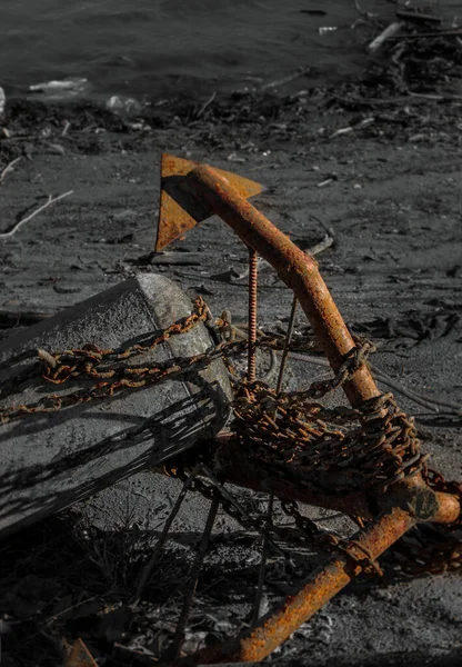 Yaşlı paslı çapa ve şamandıra kıyıda yatıyor.