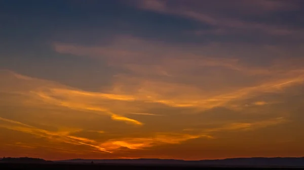 Renkli gün batımı gökyüzü, dağlar kadar uzakta.