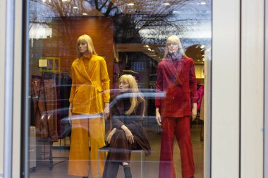 Bir vitrinde üç şık kadın manken Kara Cuma 'yı bekliyor..