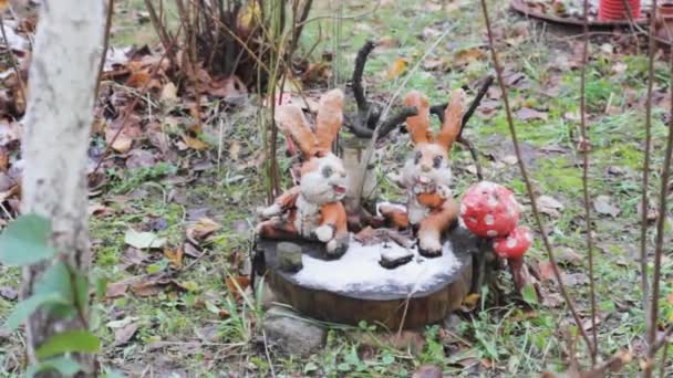 jouets lièvres dans le jardin sur une souche. neige forêt champignons décoration .