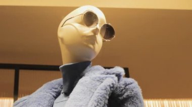 Mavi sahte kürk ceket ve yuvarlak gözlüklü manken. moda eko kürk alışverişi