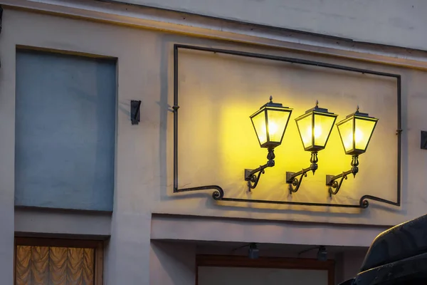 Tres luces decorativas clásicas vintage seguidas. luces amarillas y sombras . — Foto de Stock