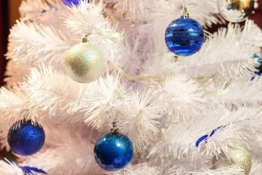 Oyuncakların içinde beyaz noel ağacı süslenmiş toplar. Kutlama Aralık Noeli