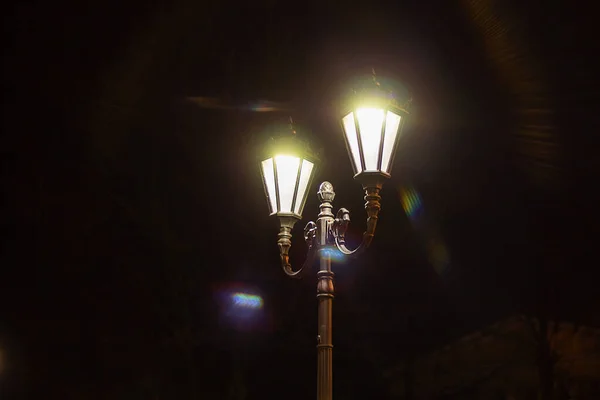 Nachtlampje in het donker. vintage lantaarnpaal in het nachtleven buiten — Stockfoto
