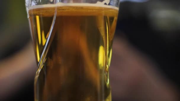 Szklankę piwa w barze. ludzie w tle patrząc telefon — Wideo stockowe