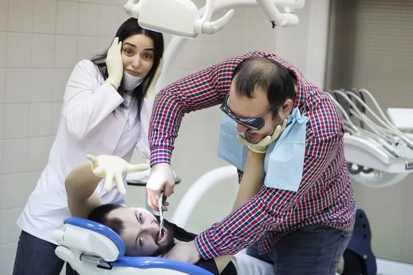 Paciente zangado vingança médico dentista para a dor. enfermeira entra em pânico — Fotografia de Stock