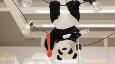 Oyuncak Panda çocuk odası eğlencesi için lambayı ters asmış.