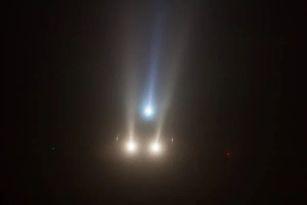 Plane lands in the fog and headlights through — Stock Photo, Image