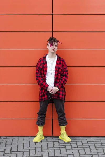 Stylish guy model on the background of orange walls. street style — Stock Photo, Image