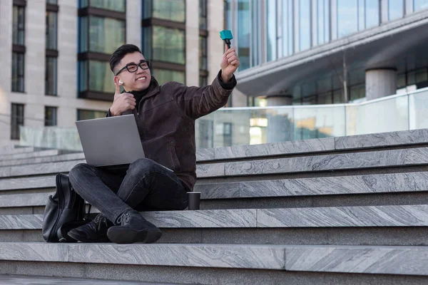 Genç erkek Asyalı blogcu, abonelerin konuştuğu bir video bloğu kaydediyor.