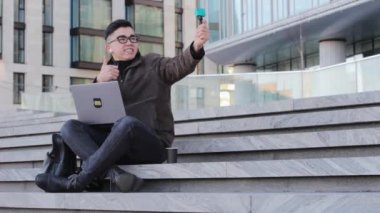 Genç erkek Asyalı blogcu abonelerle iletişim kuran bir video kamera kaydediyor