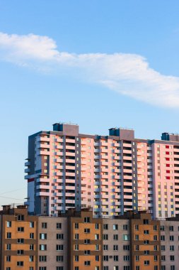 Gün batımında bulutlar çatıların üzerinde pembe şehir manzarası