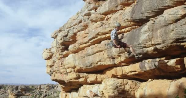 晴れた日に 懸垂ロープの助けを借りて 丘の下の登山家 — ストック動画