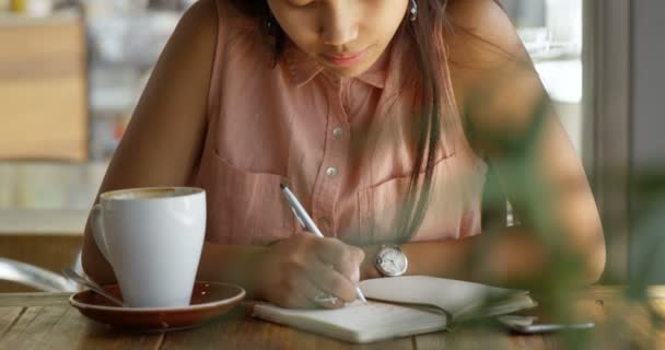 Εφηβικό Κορίτσι Γράφοντας Ένα Ημερολόγιο Στο Εστιατόριο — Αρχείο Βίντεο