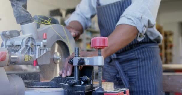 Carpenter bourání dřevěné prkno s elektrická řetězová pila v dílně 4k