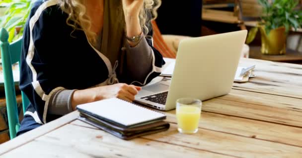 Rijpe Vrouw Met Sap Terwijl Het Gebruiken Van Laptop Bij — Stockvideo